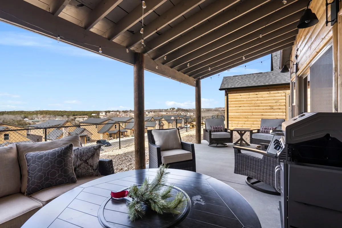 A spacious outdoor seating area featuring a grill and a sweeping view of the landscape beyond. The patio is designed for relaxation, with opportunities for outdoor dining and lounging, and offers a peaceful setting surrounded by nature.
